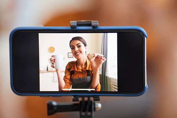 Close up of smartphone screen with a woman recording cooking tutorial for video